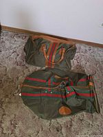 Green canvas duffel and matching garment bag with red-green stripes