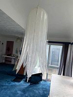 Full view of acrylic tulip pendant lamp suspended from ceiling