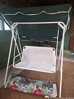 Front view of swing showing canopy, frame, cushion