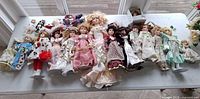 Full lot overview of porcelain dolls on table