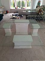 Overall view of four glass-top pedestal tables
