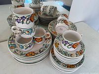 Overview of stacked dinnerware showing pattern and variety of plates and mugs
