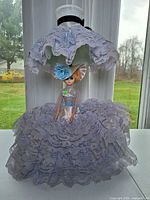 Front view of doll lamp showing lace skirt and upper shade