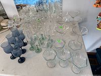 Overview of assorted stemware showing flutes, martini, dessert bowls, blue goblets, green stem glasses
