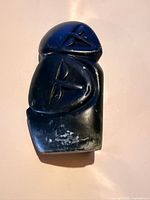 Front of dark stone abstract sculpture with carved details