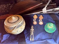 Group view: lidded basket, candlesticks, figurine, green basket