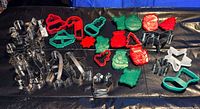 assorted metal and plastic Christmas cookie cutters spread on table