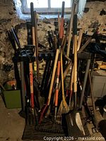 Full rack of assorted long-handle yard tools