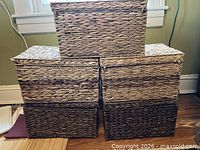 Front view of six of the woven baskets stacked to show size and lid style