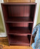 Front full view of dark wood laminate bookcase, three shelves visible