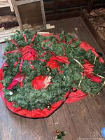 Stacked large and small artificial wreaths with red bows and ornaments