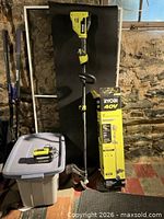 Full view of assembled Ryobi 40V trimmer standing next to original box and battery on tote