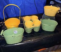 Group shot of yellow mesh basket, oval buckets, four small pots, and caddy
