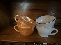 Stacked teacups showing two peach lustre and two white with gold rim