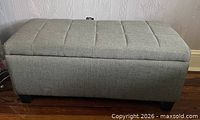 Front view of gray upholstered ottoman bench closed