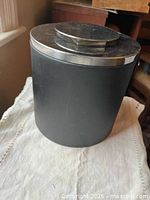 Full view of black faux leather ice bucket with lid on