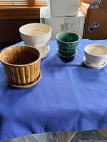 Four McCoy planters with saucers in assorted glazes