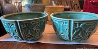 Two McCoy planters side by side showing exterior ivy relief and glaze
