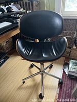 Front view showing black vinyl seat/back and wood veneer edges