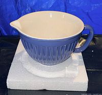 Side view of blue ceramic mixing bowl on styrofoam base