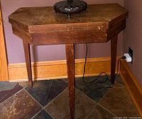 Table folded, front view showing drawer and legs