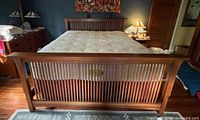 Front view of assembled Mission style oak bed with mattress and box spring