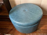 Closed ottoman top view showing vinyl upholstery and button tuft