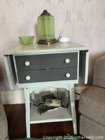 Side table front view with leaves down showing two drawers, lower shelf