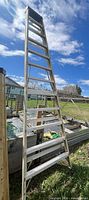 Full view of 12ft aluminum straight ladder leaning outdoors