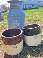 Stoneware crock and milk can side by side outdoors