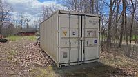 Front view of beige 22 ft container showing dual doors, lock bars, exterior markings