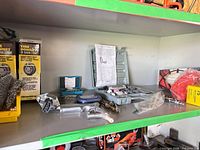 Shelf view with pneumatic grinder, grey case of grinding stones, blue case dial indicator, assorted fittings, plastic bag parts