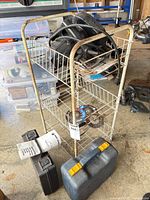 Wire rack holding Black & Decker Heat 'N Strip heat gun, circular saw, spare blade, two hard cases, sanding pads