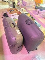 Two black hard-shell Carlton suitcases side by side showing overall size difference and exterior wear