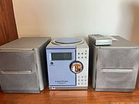 Stereo system showing main unit, two speakers, remote on right speaker