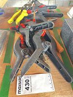 assortment of clamps, locking pliers and tin snips on workbench