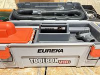 Overall view of Eureka Toolbox Vac with hose and brush nozzle inside case