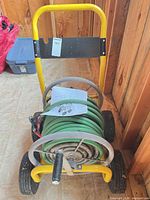 Front view of hose cart with hose, nozzle and manual visible