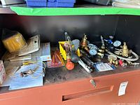 Shelf with assorted gauges, regulators, tools and hoses
