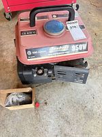 Portable generator showing fuel tank, handle, labels 950W