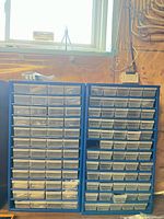 Front view of two blue metal parts organizers with many small plastic drawers
