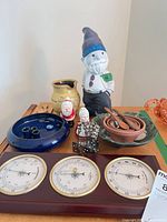 Group shot of all items including gnome, weather station, pottery, figurines, spoons, bowls and metal pieces