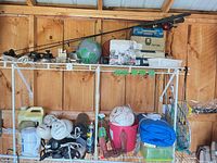 Shelf with fishing rods, tackle boxes, nets, soccer ball and assorted gear