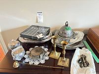 Entire lot on dresser: platters, covered dish, wrapped sugar/cream pieces, coaster set, ladle, candlesticks, brass pulls