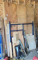 overall stack with large sheets, smaller panels, short boards visible