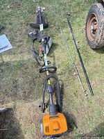 Full layout of trimmer powerhead, shafts, pole saw attachment, guard and strap on ground