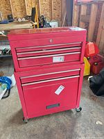 Front view of red two-piece rolling tool chest showing drawers and casters