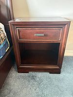 Front view of nightstand showing drawer, open shelf, overall design and finish
