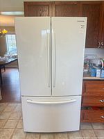 Front view of white Samsung French door refrigerator with bottom freezer drawer