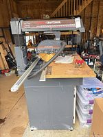 Radial arm saw on stand with accessories on table